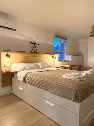 a bedroom with a large bed with a wooden headboard at Casa Jazmin in Alora