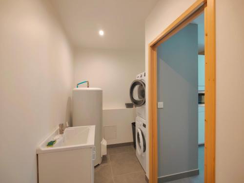 a bathroom with a sink and a washing machine at À la Volette - Cosy, Nature & Miel des Vosges in Plombières-les-Bains