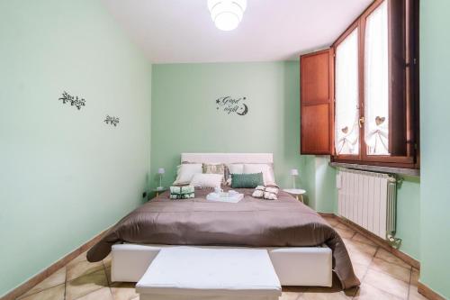 a bedroom with a large bed with green walls at La Casetta del Suffragio in Viterbo