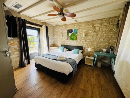 a bedroom with a bed and a ceiling fan at Le Pigeonnier du Perron Hôtel in Availles en Chatellerault