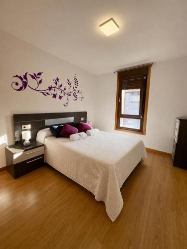 a bedroom with a large bed with purple flowers on the wall at O LAR DE MARTINA in Redondela