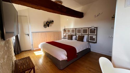 a bedroom with a large bed in a room at Le Pigeonnier du Perron Hôtel in Availles en Chatellerault