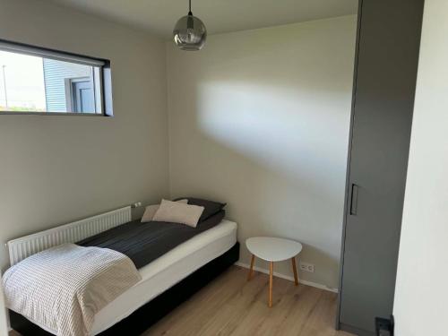ein kleines Schlafzimmer mit einem Bett und einem kleinen Tisch in der Unterkunft Dalsbraut in Njarðvík