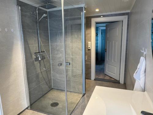 a bathroom with a shower with a glass door at Horgheim Boutique Lodge, Romsdalen in Åndalsnes