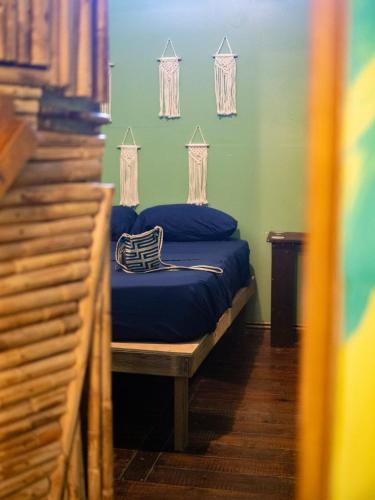 a bedroom with a bed with blue sheets and windows at Boca Estrella in Bocas Town