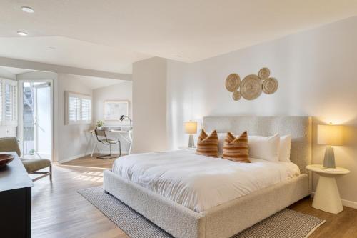 a bedroom with a large white bed with pillows at The Mara Laguna Beach, an AvantStay Hotel in Laguna Beach