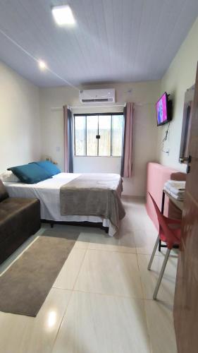 a bedroom with a bed and a couch and a window at Casa Inteira com Garagem, no Goiabal até 3 hospedes in Macapá