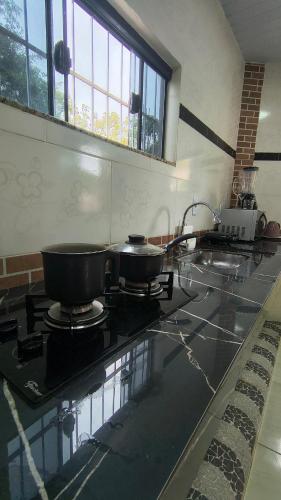 a kitchen with two pots and pans on a stove at Casa Inteira com Garagem, no Goiabal até 3 hospedes in Macapá