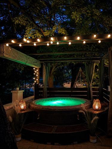a hot tub under a pergola with lights at Luxury House Cesarica in Cesarica