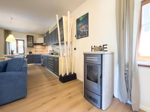 a living room with a blue couch and a kitchen at Casa del Torchio in Giovo