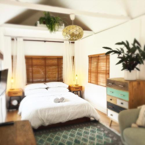 a bedroom with a white bed with a green rug at River Cabin Retreat in Shepperton
