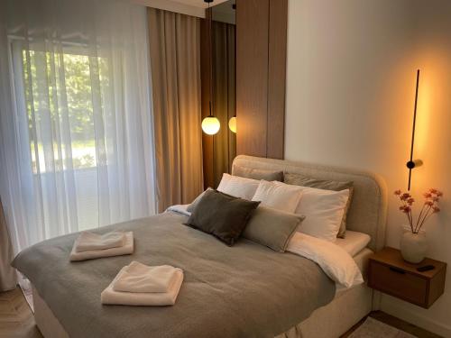 a bedroom with a bed with two towels on it at Casella Apartment E34 Let's Sea Baltic Park in Gąski