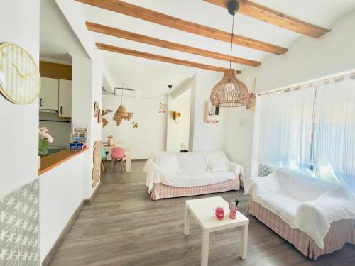 a white living room with two beds and a table at Villabett Caudiel está de moda in Caudiel