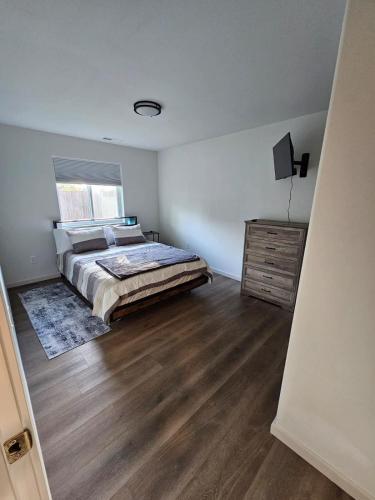 a bedroom with a bed and a wooden floor at Southern Charm on Earl in Stanfield