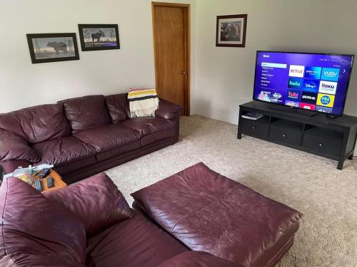 a living room with a couch and a flat screen tv at Gravel Road Getaway in Hermiston