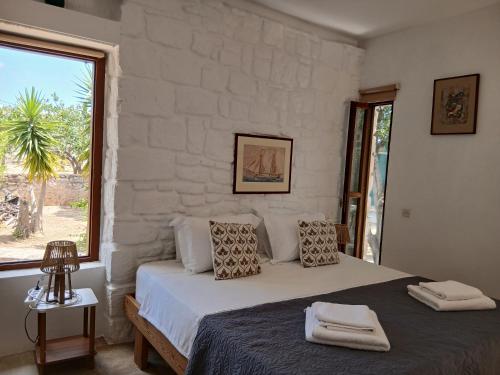 a bedroom with a bed and a large window at Egina Home in Egina