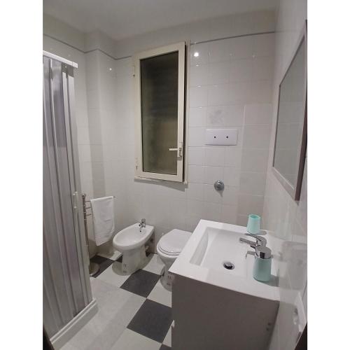 a white bathroom with a sink and a toilet at Dolcecasa in Misilmeri