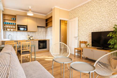 a living room with a couch and chairs and a tv at Panorama - Lake Maggiore House in Colazza