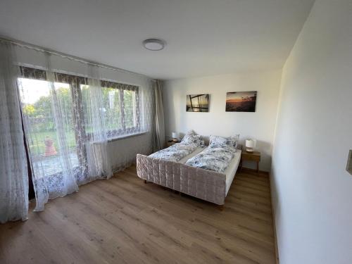 a bedroom with a bed and a large window at Private Garden Apartment near Bad Schallerbach in Wallern an der Trattnach