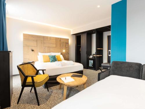 ein Hotelzimmer mit einem Bett und einer Couch in der Unterkunft Mercure Epinal Centre in Épinal