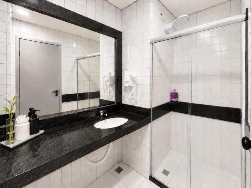 a bathroom with a sink and a mirror at Flat vista Mar -conforto e estilo em Ponta Negra-Natal in Natal