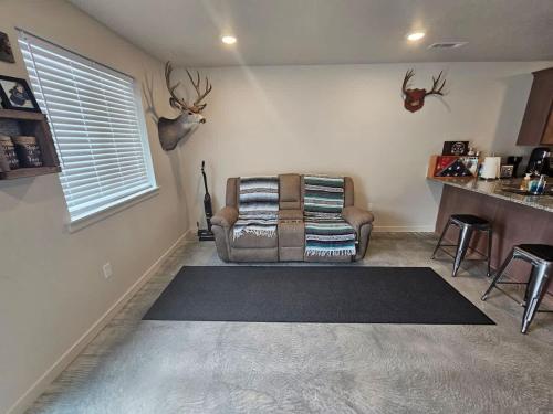 a living room with a couch and antlers on the wall at Cozy 2BR Home Parking Full Kitchen in Stanfield