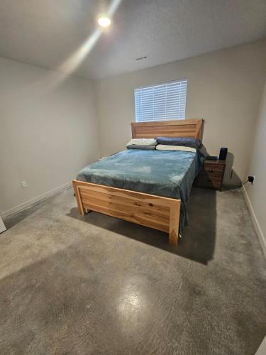 a bedroom with a wooden bed and a window at Cozy 2BR Home Parking Full Kitchen in Stanfield