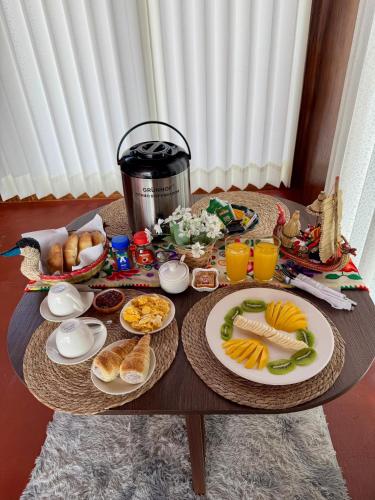 a table with breakfast foods and drinks on it at Titicaca House Mariela in Puno