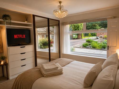 a bedroom with a bed and a tv and a window at Randall Farm Near Brands Hatch Circuit in Fawkham
