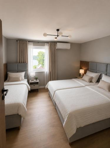 a bedroom with two beds and a window at Apartamenty Sznurki in Sznurki
