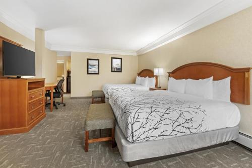 a hotel room with a bed and a desk and a television at Best Western Plus Silver Saddle Inn in Estes Park