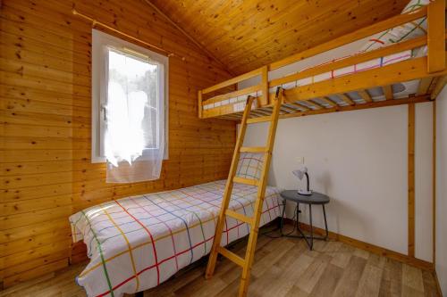a bedroom with a bunk bed in a cabin at Comfortable chalet in a vacation village in Gujan-Mestras