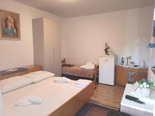 a small room with two beds and a refrigerator at Sobe Centar Baška Voda in Baška Voda