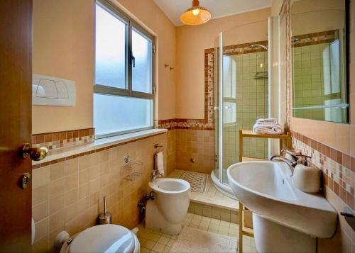 a bathroom with a toilet and a sink and a shower at Greto al Mare in Francavilla al Mare
