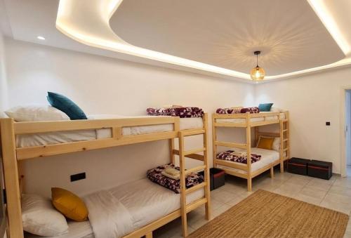a room with three bunk beds and a ceiling at Hostel the little prince in Tarfaya