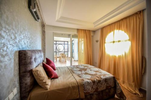 a bedroom with a bed and a window at Spacious apartment, pool, beach, basement parking in Bouznika