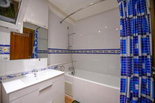 a bathroom with a sink and a tub and a shower at Spacious apartment, pool, beach, basement parking in Bouznika