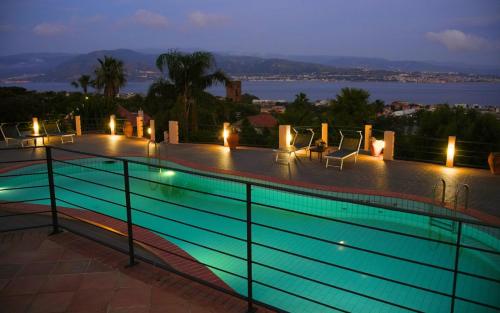 a swimming pool at night with a view of the water at Sicily in Villa in Messina