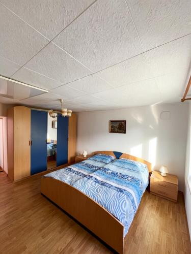 a bedroom with a large bed with a blue comforter at House Flajs - secluded 2BR Surrounded by Forest in Soča