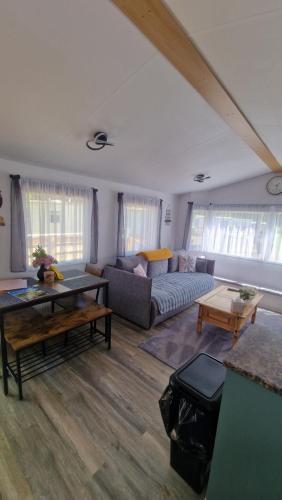 a living room with a couch and a table at Forest Valley Holiday Home in Ballantrae