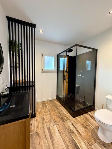 a bathroom with a glass shower and a toilet at La Perle charmante maison avec parking privé in Mers-les-Bains
