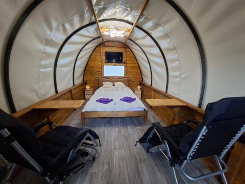 an overhead view of a room with a bed and two chairs at Czarci Zakątek in Pozezdrze
