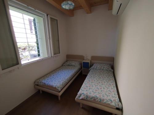 two beds in a room with a window at Da Zia Vecchia 1 in Cervia