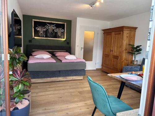 a bedroom with a bed and a table and a chair at Ferienwohnungen Boxler in Oberstdorf