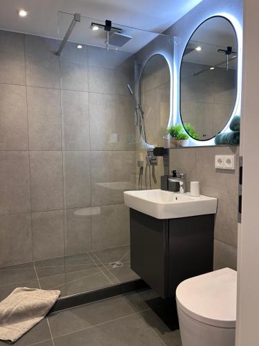 a bathroom with a sink and a toilet and a mirror at Ferienwohnungen Boxler in Oberstdorf