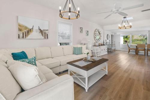 a living room with a white couch and a table at Poolside Palms - Team Joseph Ellen in Jacksonville Beach