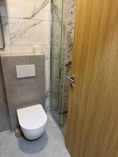 a bathroom with a toilet and a wooden door at Apartman 38 in Stara Pazova