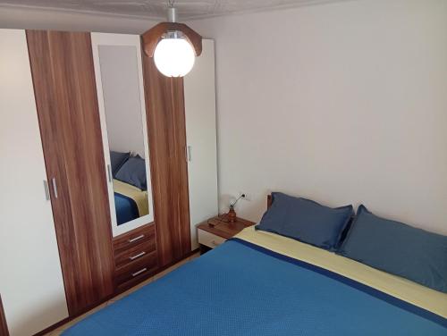 a bedroom with a blue bed and a mirror at Apartment Mara in Ankaran