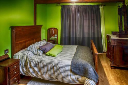 a bedroom with green walls and a bed with green pillows at La Casina del Pozo in Bembibre