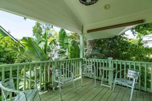 a white porch with chairs and tables and trees at Riberia Columbus Cottage - Team Joseph Ellen in St. Augustine